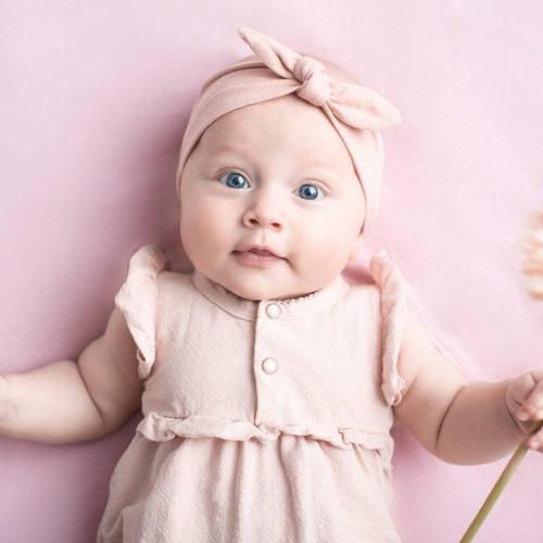 Wunderschönes Baby mit Blume in der Hand bei einem Meilenstein Fotoshooting von Siebenschön Photography in der Nähe von Ahlen