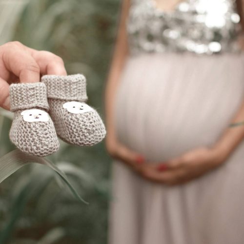 Babybauchshooting mit kleinen Schuhen im Vordergrund fotografiert von Siebenschön Photography in Drensteinfurt