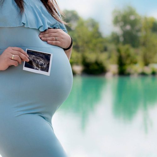 Babybauchfoto mit einem Ultraschallbild in freier Natur fotografiert von Siebenschön Photography in Sendenhorst